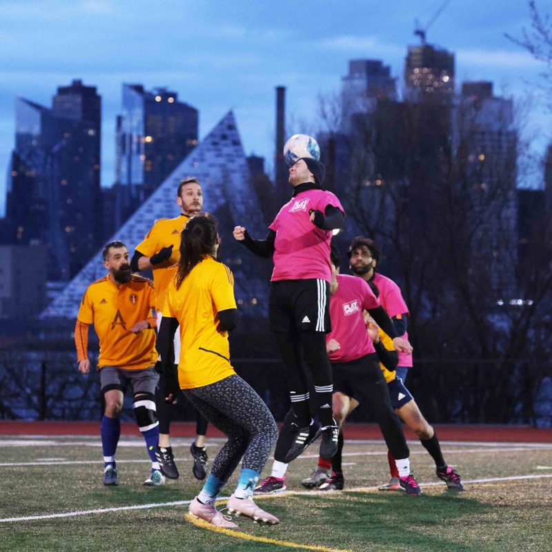 NJ Play Sports soccer league - header battle under the NYC skyline